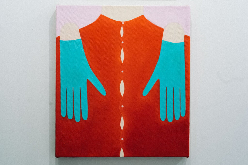 A painting of a red shirt with buttons and two hands in turquoise gloves over the shoulders, touching the chest from above.