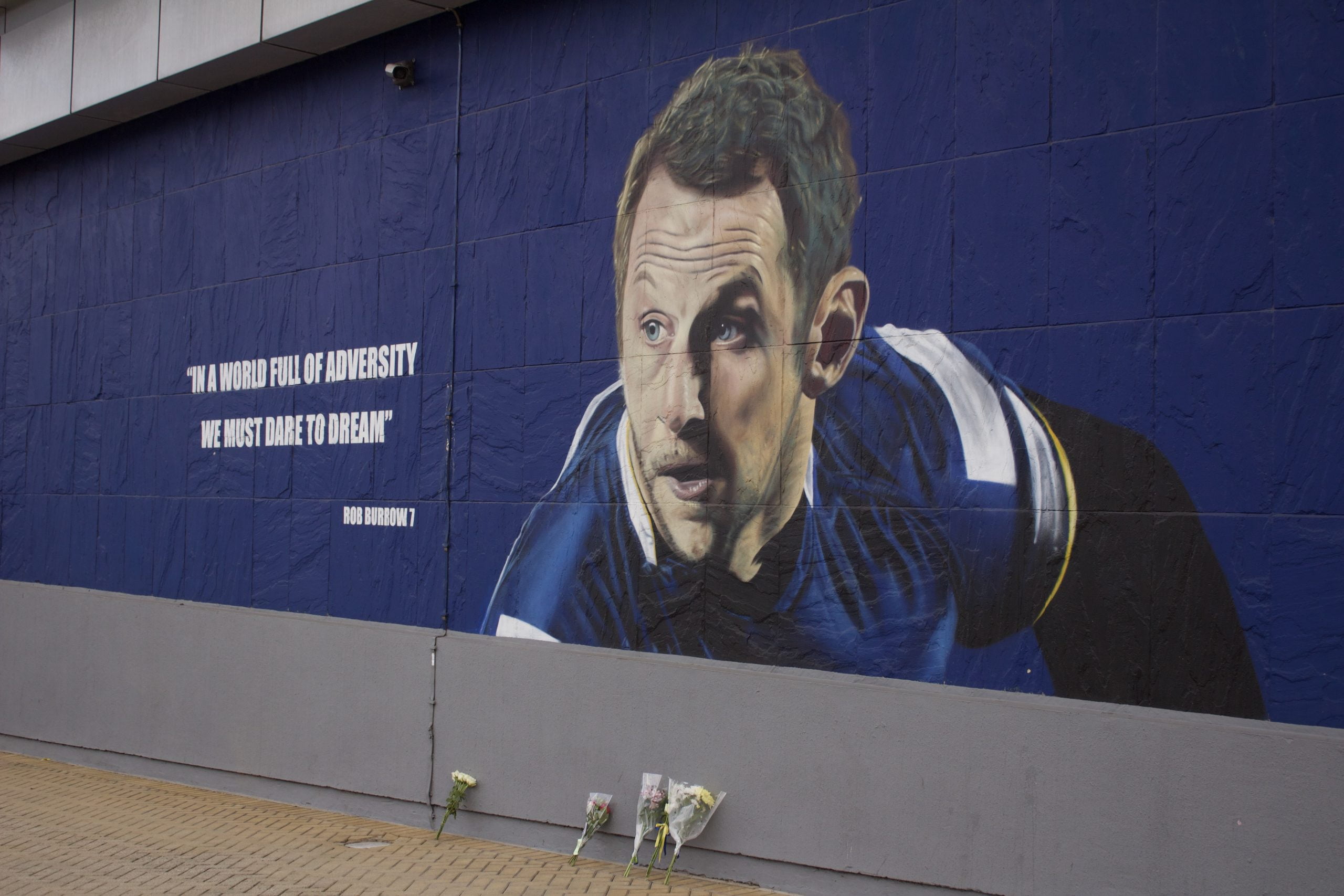 Rob Burrow mural on the side of a wall. The text reads "in a world full of adversity, we must dare to dream" - Rob Burrow