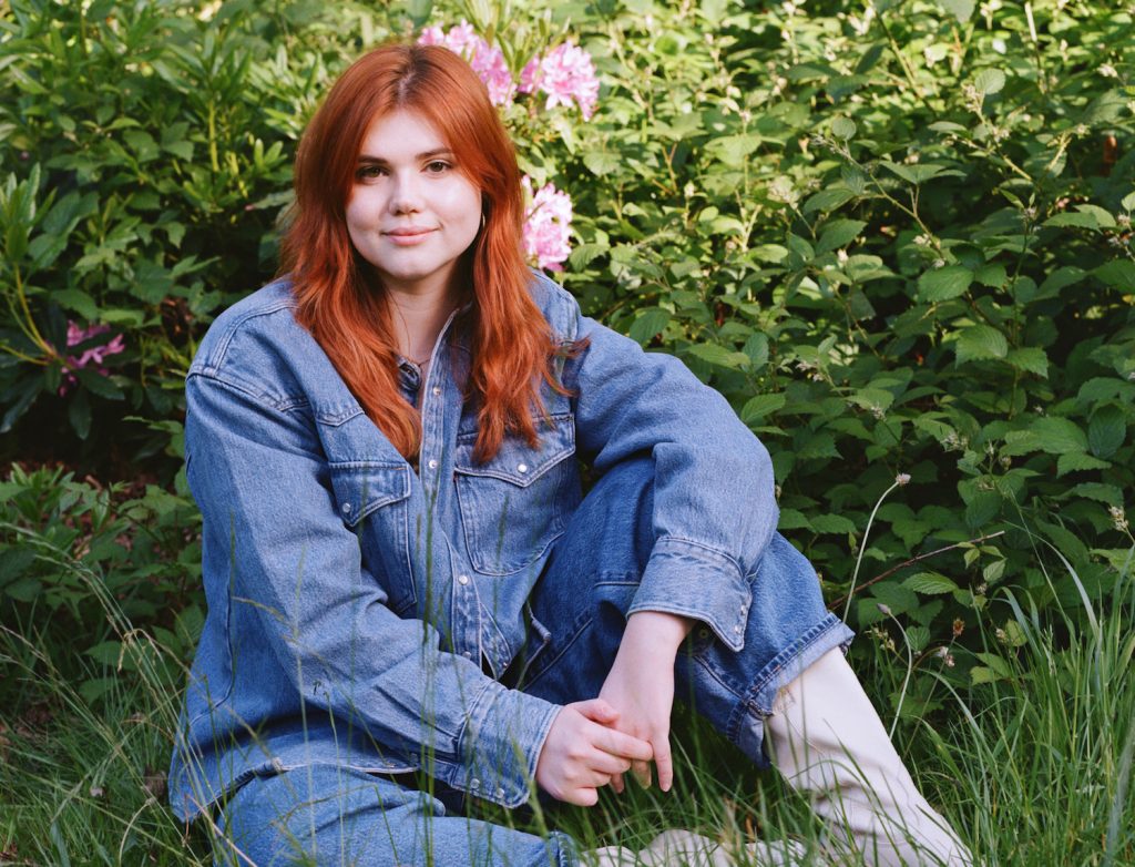 Picture of Eliza Clark sat outside in a blue outfit