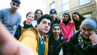 Photo of a group of young people stood outside looking into the camera.