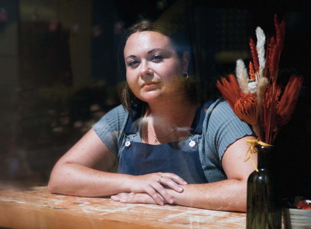 Image of Maria Ferguson sat in a coffee shop window. 